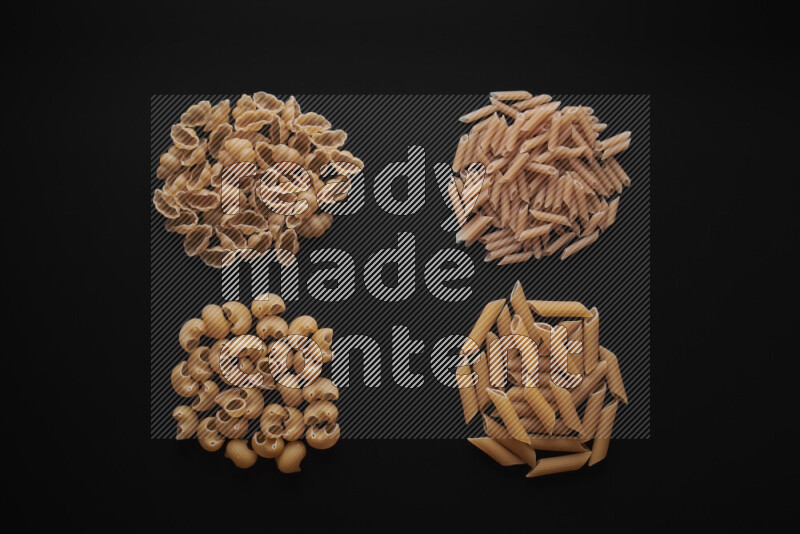 Different pasta types in bunches on black background