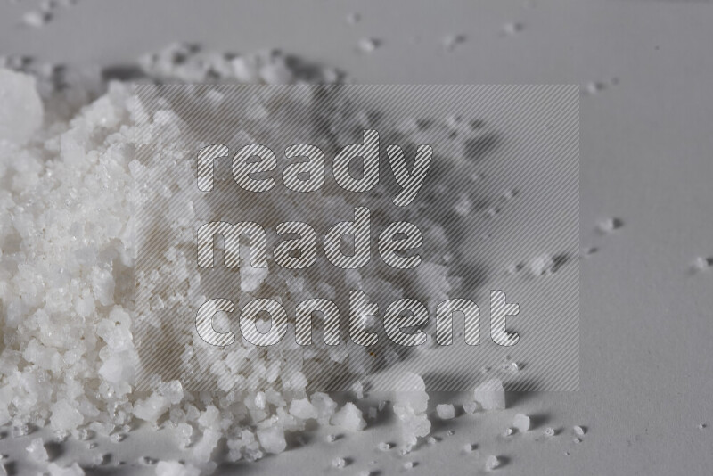 A bunch of coarse sea salt crystals on white background