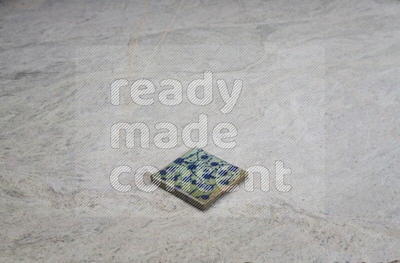 Top view shot of a pottery coaster\ tile on beige marble flooring