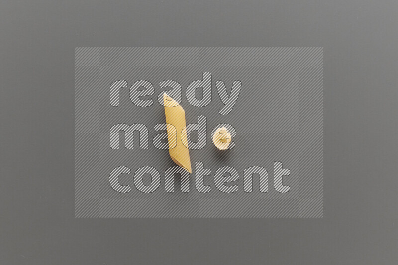 Penne pasta with other types of pasta on grey background