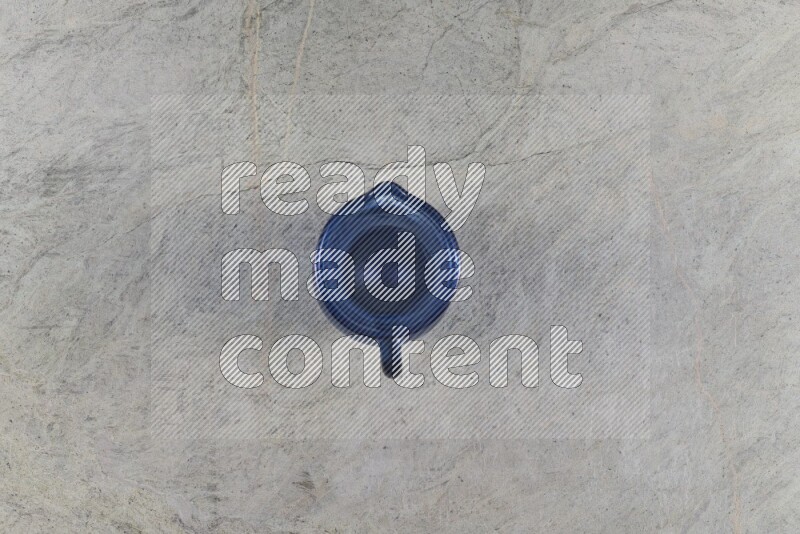 A colored glass jug on grey marble background