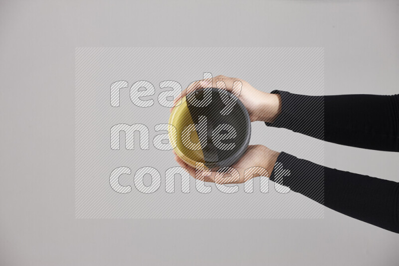 A woman in black abaya holding different pottery essentials in different positions
