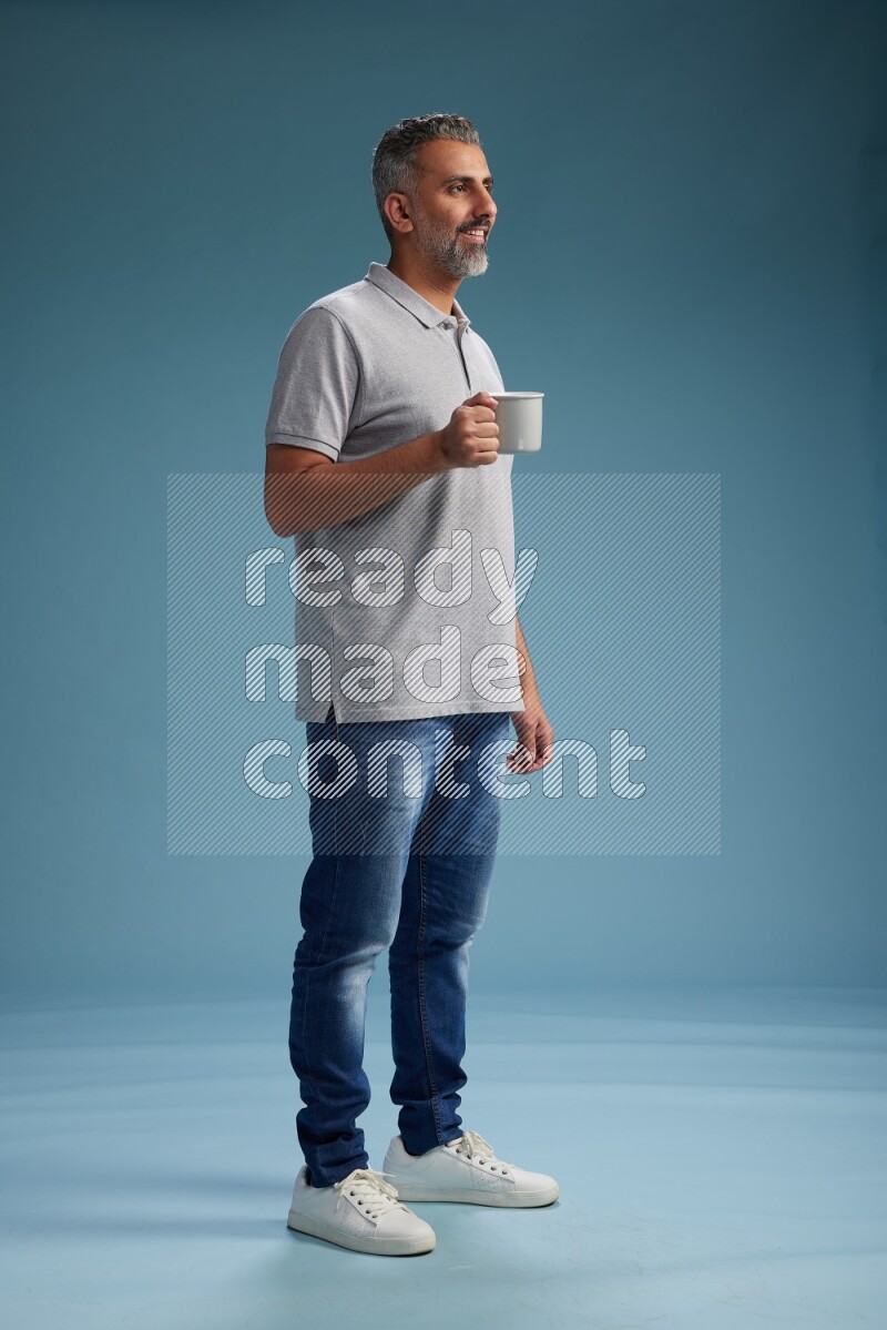 Man Standing drinking coffee on blue background