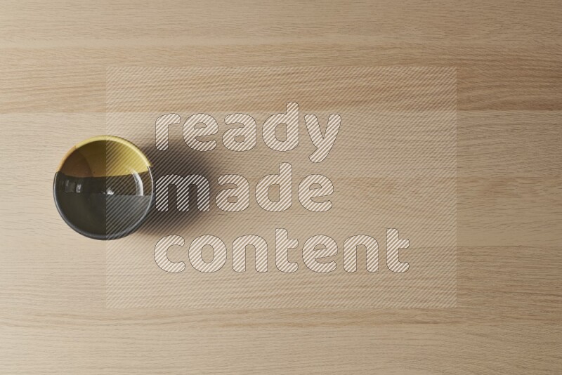 A multicolored pottery bowl on light wooden background