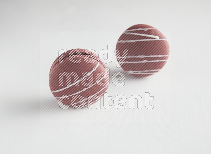 45º Shot of two Red Poppy Flower macarons on white background