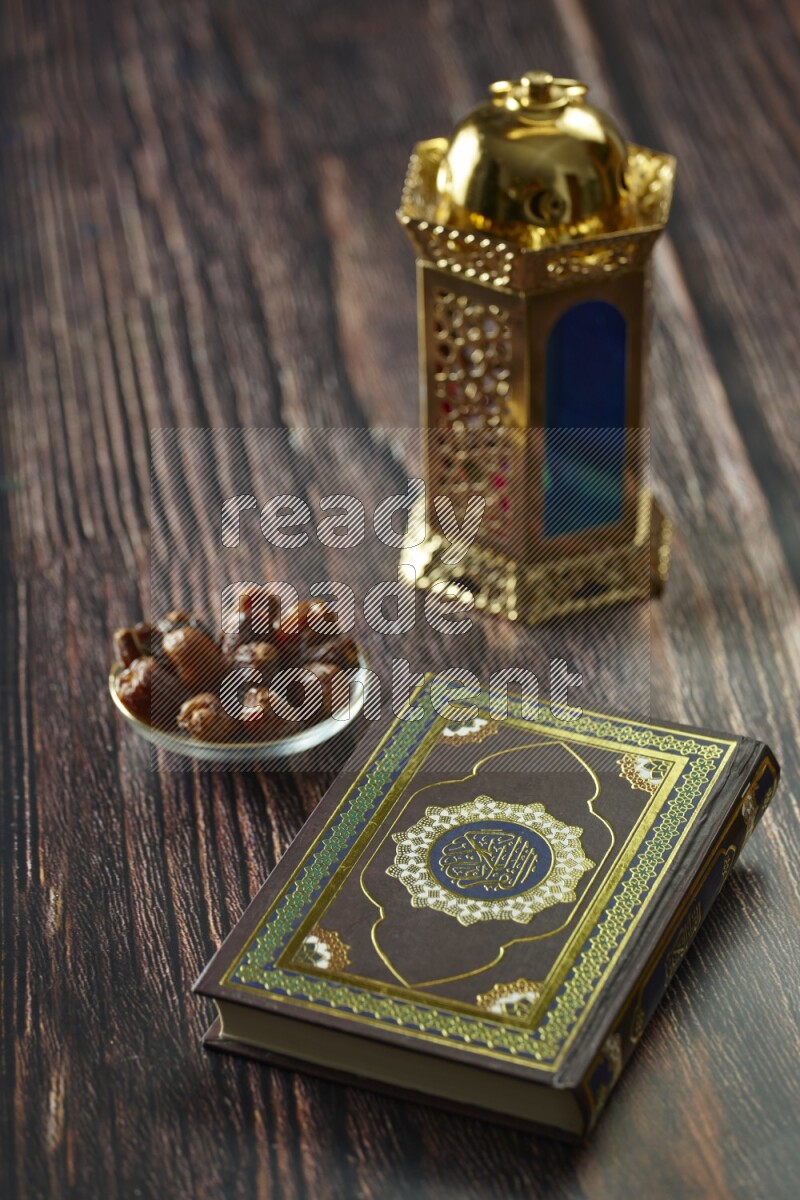 A golden lantern with different drinks, dates, nuts, prayer beads and quran on brown wooden background