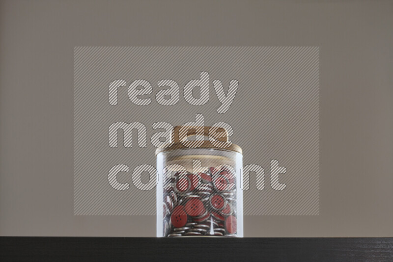 Buttons in a glass jar on black background