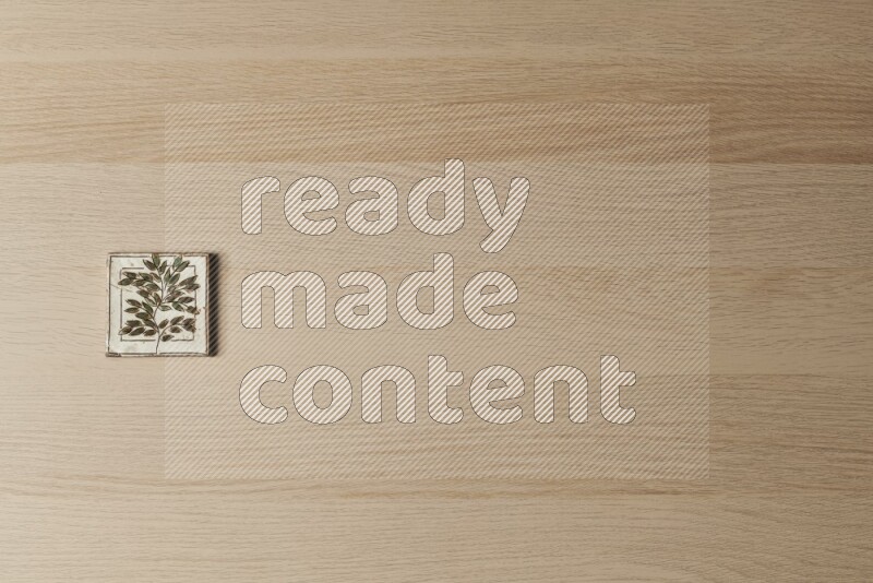 A decorative pottery coaster on light wooden background
