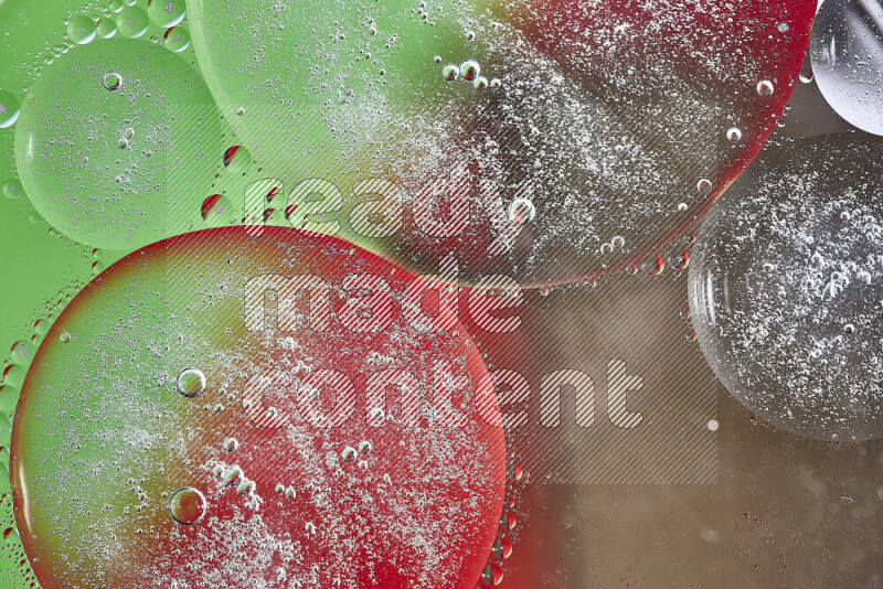 Close-ups of abstract oil bubbles on water surface in shades of brown, green and red