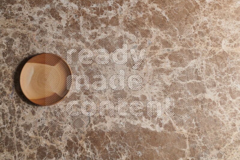 A multicolored pottery plate on beige marble background