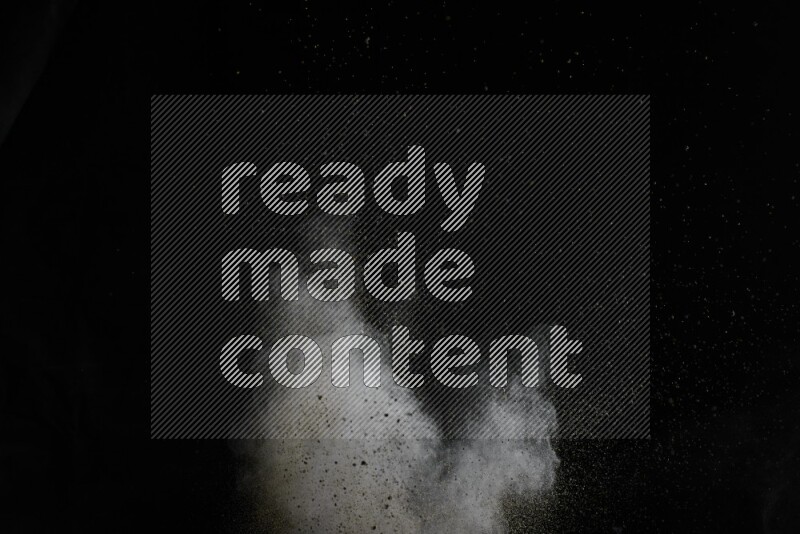 A side view of brown powder explosion on black background