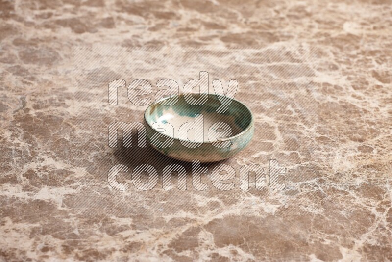A multicolored pottery plate on beige marble background