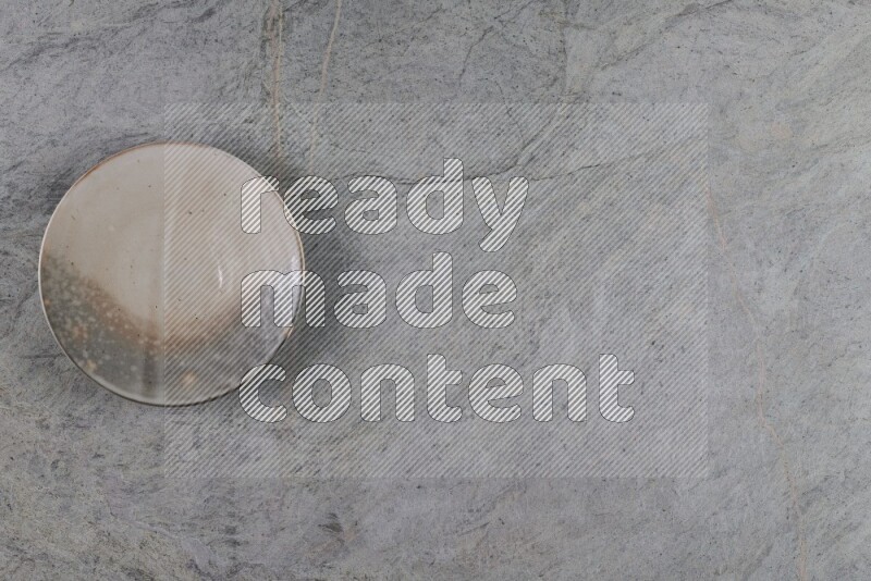 A multicolored pottery plate on grey marble background