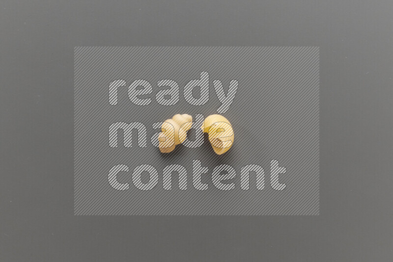 Snails pasta with other types of pasta on grey background