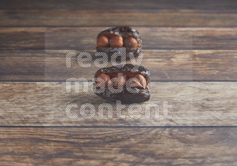 two hazelnut stuffed madjoul date on a wooden background