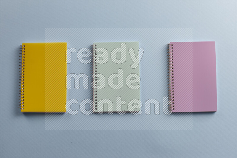 Multicolored notebooks with different school supplies on blue background