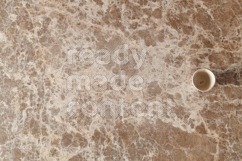 A pottery cup on beige marble background