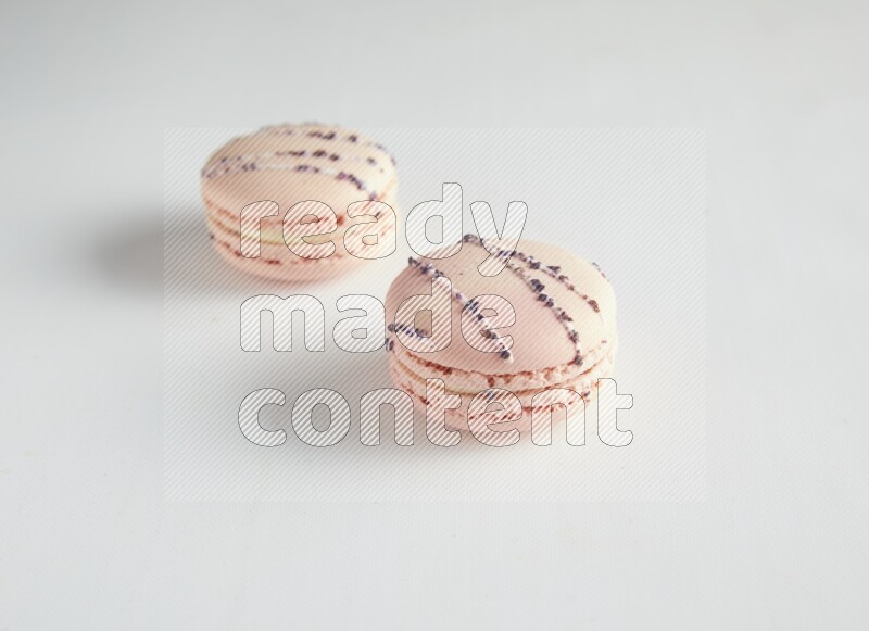 45º Shot of two pink orange blossom macarons on white background