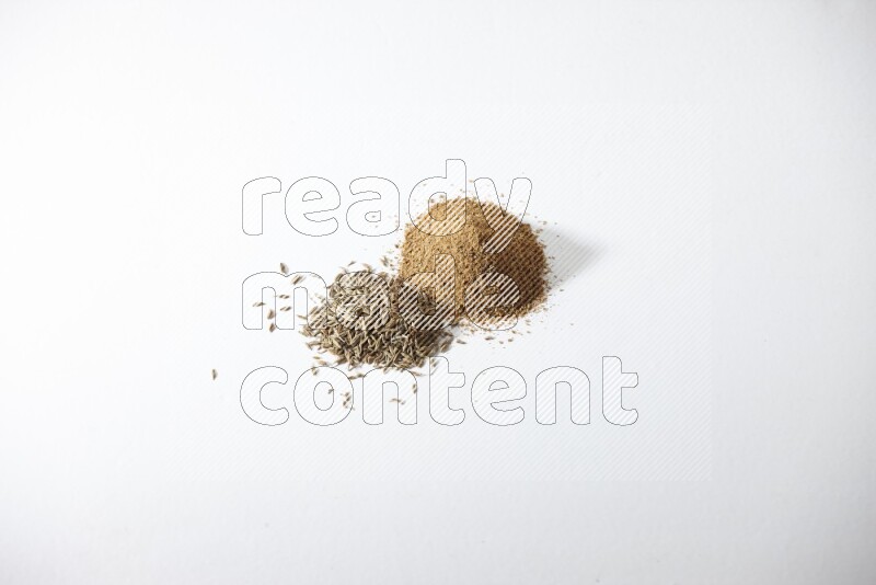 حبوب وبودرة الكمون علي خلفية بيضاء