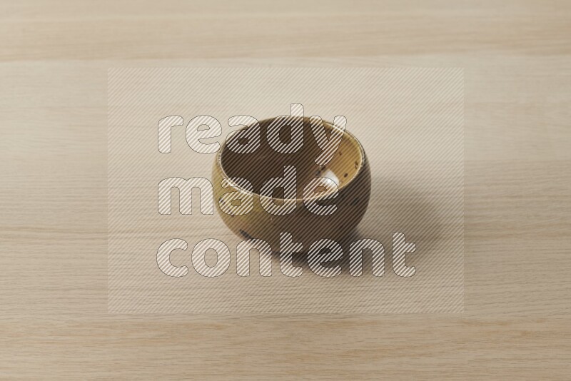 A multicolored pottery bowl on light wooden background