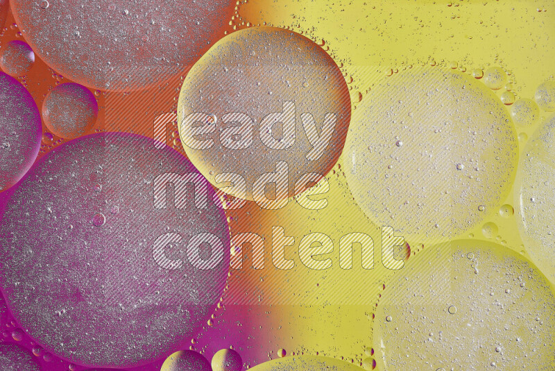 Close-ups of abstract oil bubbles on water surface in shades of yellow, orange and pink
