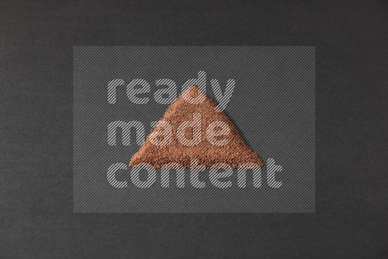 Garden cress seeds in a triangle shape on a black flooring