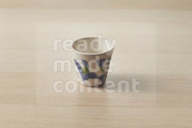 A pottery cup on light wooden background