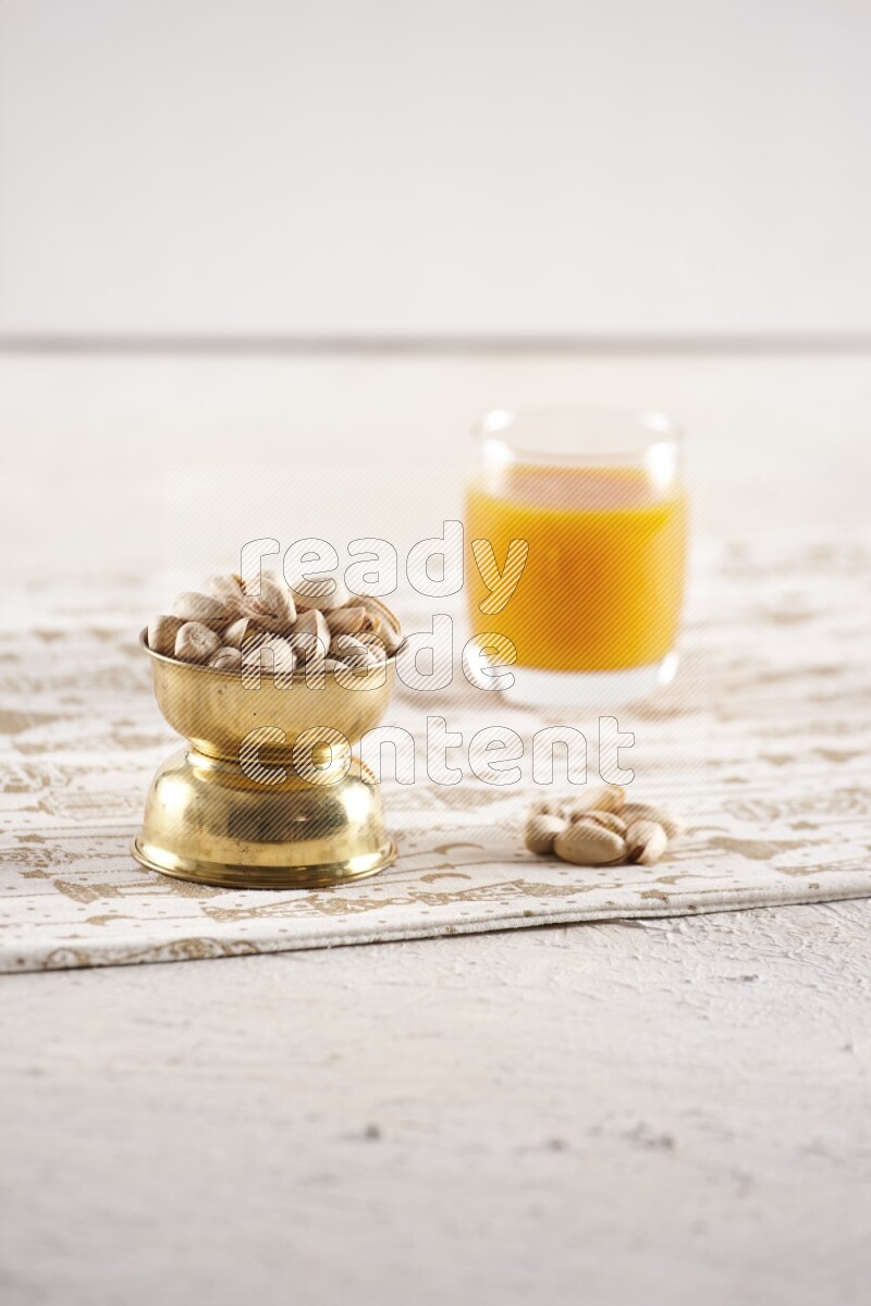 Nuts in a metal bowl with qamar eldin in a light setup