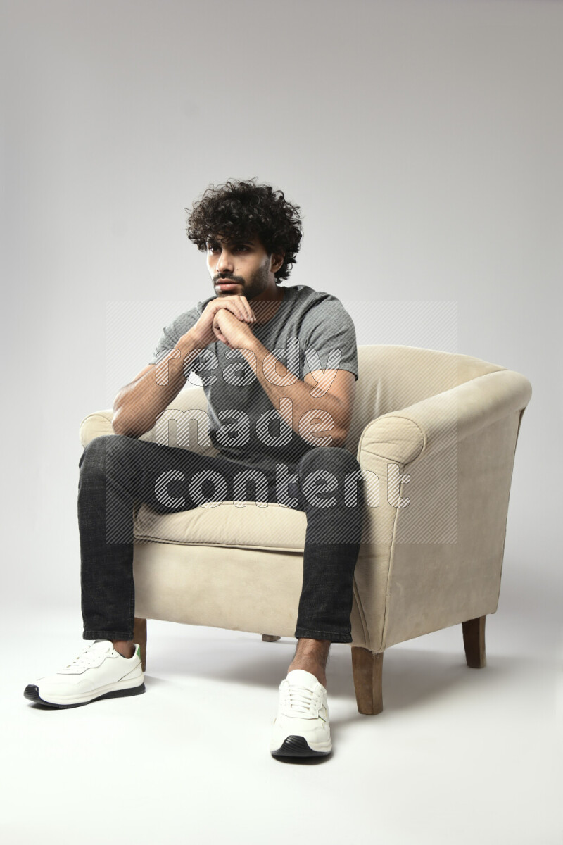 A man wearing casual sitting on a chair making a hand gesture on white background