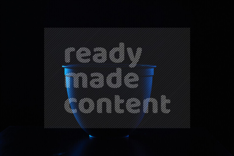 A reflector diffuser lamp shade dish with colored rim light against black background