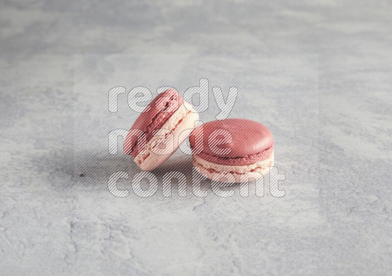 45º Shot of two Pink Litchi Raspberry macarons  on white  marble background