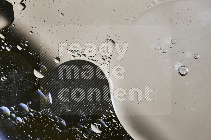 Close-ups of abstract oil bubbles on water surface in shades of black and beige