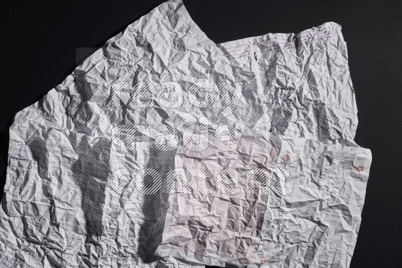 Crumpled notebook sheet on black background