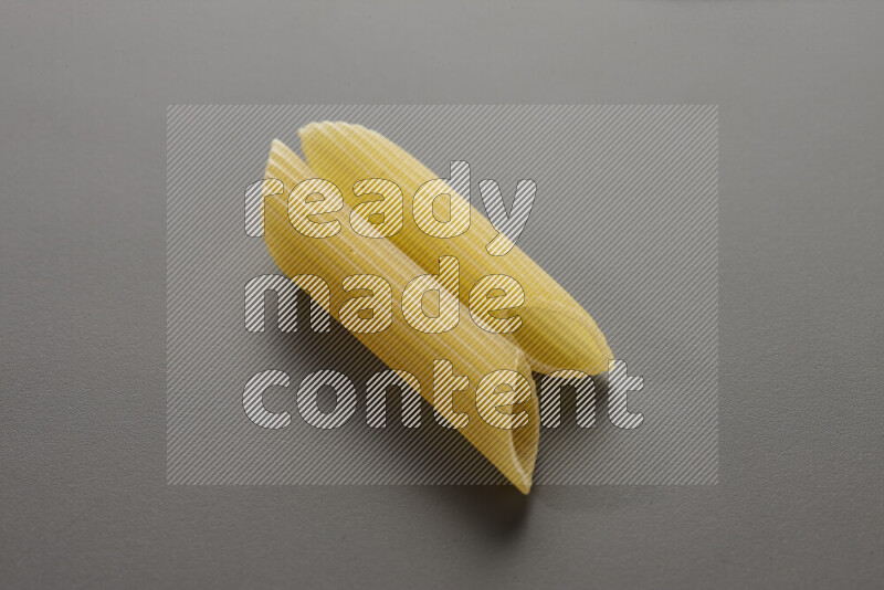 Penne pasta on grey background