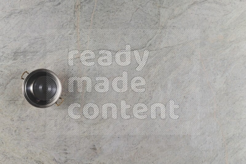 A small copper pot on grey marble background