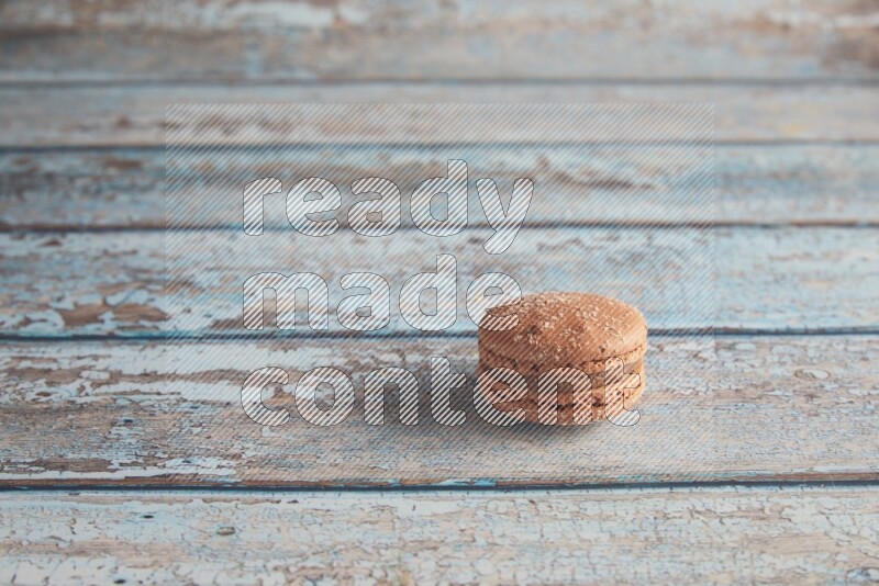 45º Shot of Brown Hazelnuts macaron on light blue wooden background