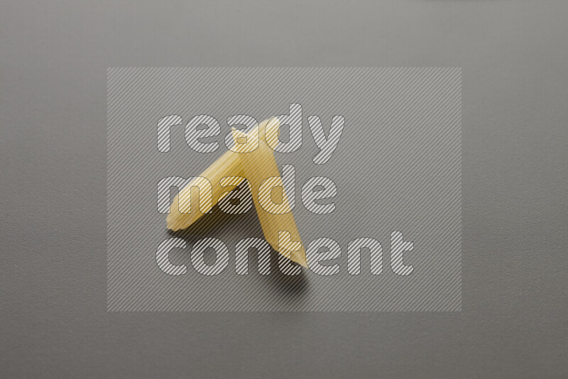 Mini penne pasta on grey background