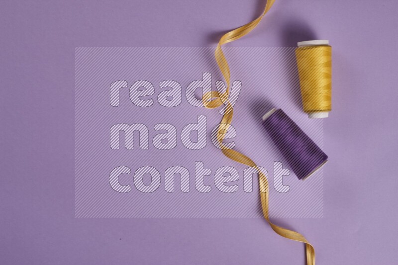 A yellow and purple collection of sewing and tailoring tools arranged on a purple background