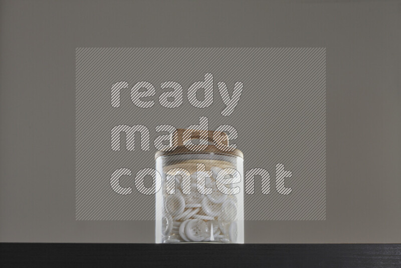 Buttons in a glass jar on black background