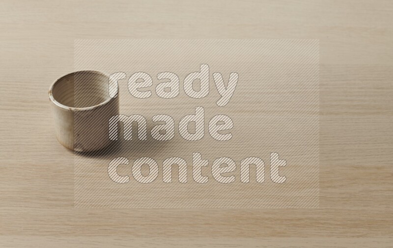 A pottery cup on light wooden background