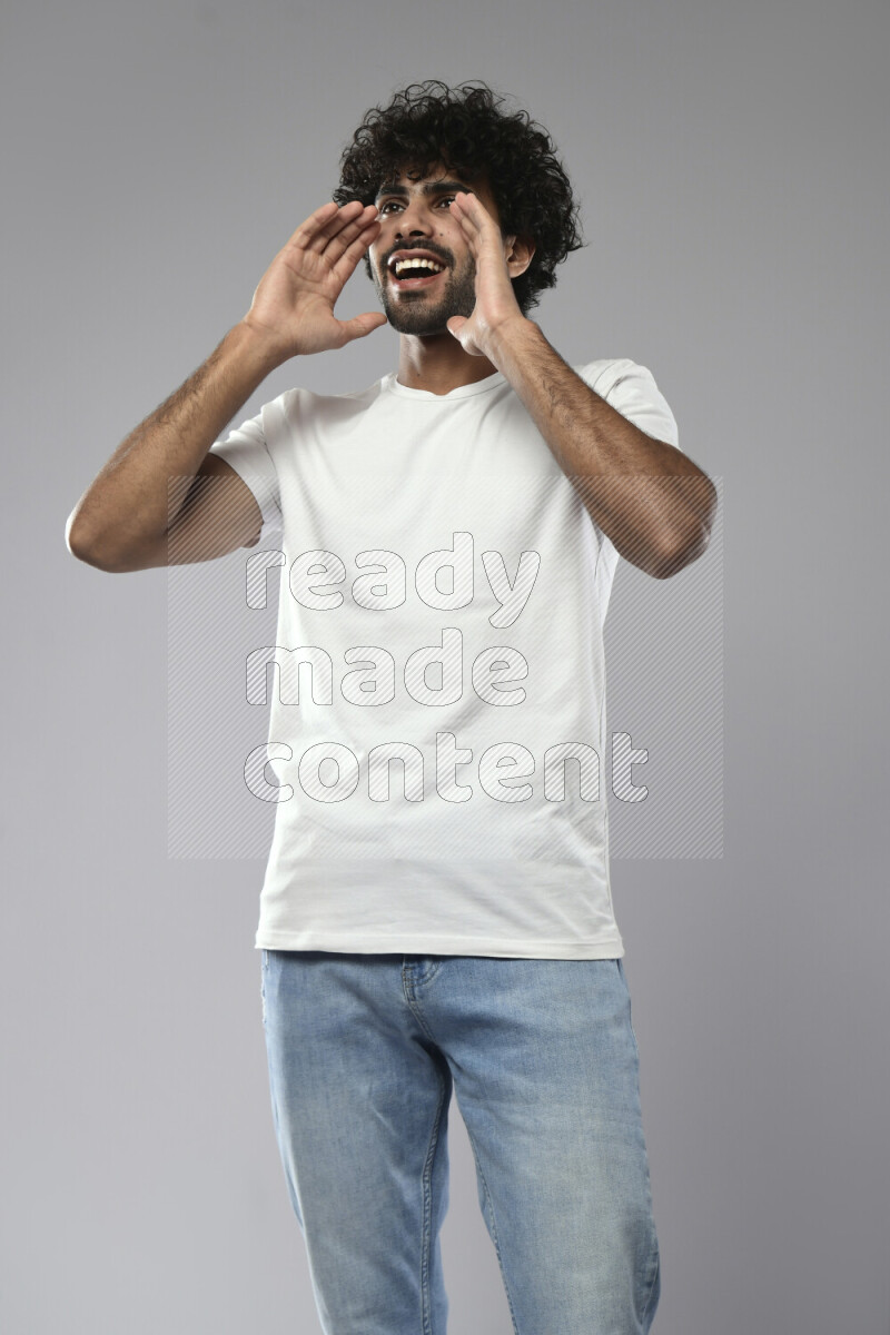 A man wearing casual standing and making a hand gesture on white background