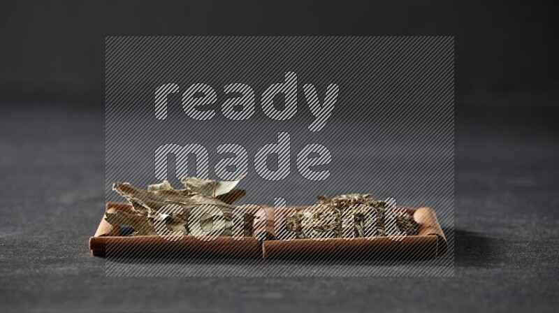 2 squares of cinnamon sticks full of cumin and bay laurel leaves on black flooring