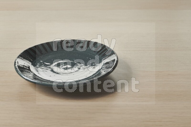 A multicolored pottery plate on light wooden background