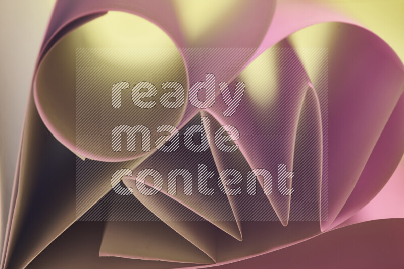 An artistic display of paper folds creating a harmonious blend of geometric shapes, highlighted by soft lighting in pink and warm tones