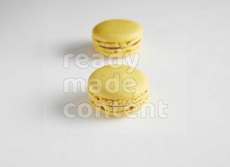 45º Shot of two Yellow Lemon macarons on white background