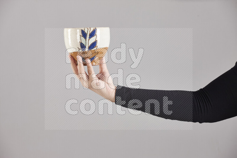 A woman in black abaya holding different pottery essentials in different positions