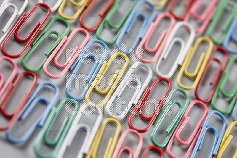 Multicolored paper clips isolated on a grey background
