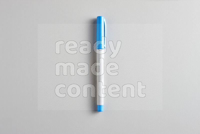 A close-up showing a single coloring pen with a cap on grey background