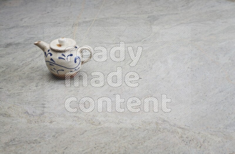 A pottery teapot on grey marble background