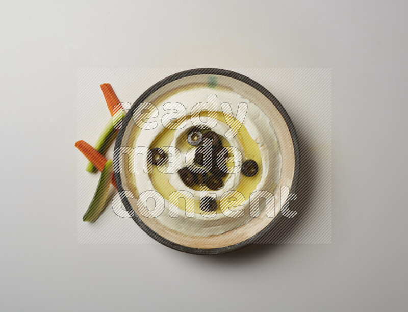 Lebnah garnished with sliced olives in a pottery plate on a white background